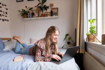 a student lying in a dorm room